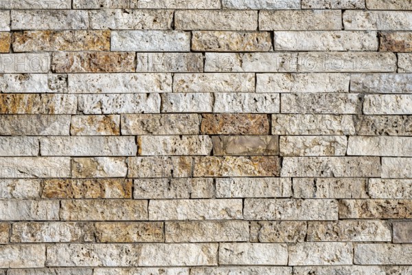 Background consisting of a wall of beige and brown clinker bricks