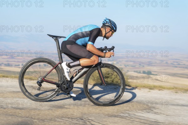 Cyclist riding the bike in the road descending the hill