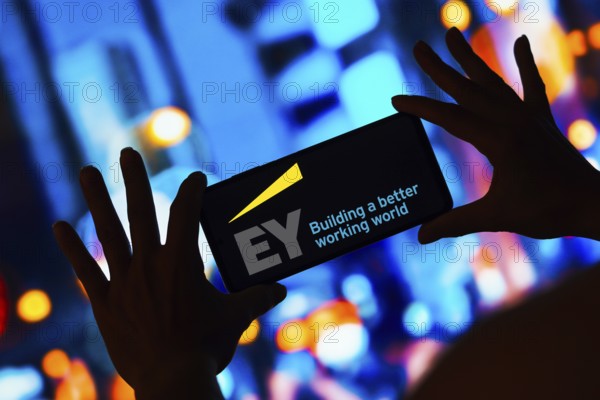 In this photo illustration, the Ernst and Young Global Limited (EY) logo is displayed on a smartphone screen