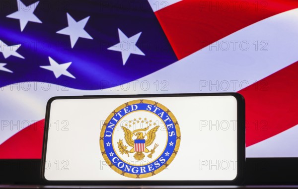 In this photo illustration the United States Congress logo seen displayed on a smartphone screen, United States of America flag in the background