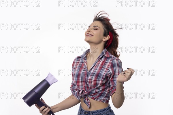 A young woman is playfully drying her hair while exuding both confidence and pure joy in her expression