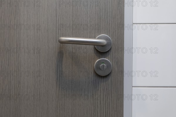 A stylish door handle rests on a beautiful wooden surface, perfectly showcasing modern design and true elegance