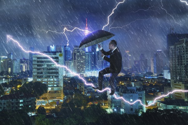 Junger Geschäftsmann mit Regenschirm gegen Gewitter. Herausforderungen und Krisenkonzept zu überwinden. Mischmedien