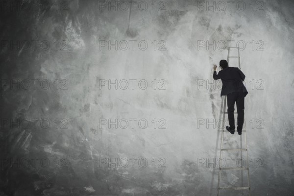Männer zeichnen auf leere graue Wand