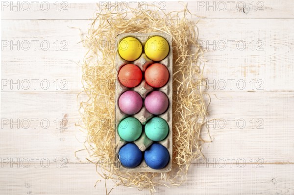 Easter concept. Colorful eggs on white wooden background with copy space for text or design. Top down view or flat lay