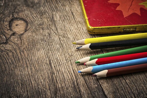 Set of colored pencils on wooden unhewn background.photo tinted
