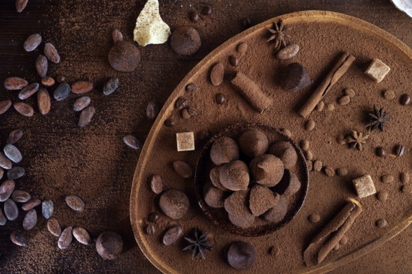 Healthy delicious chocolate truffles around ingridients with natural cocoa beans, powder, cacao butter, cane sugar. healthy sweets concept. flat lay