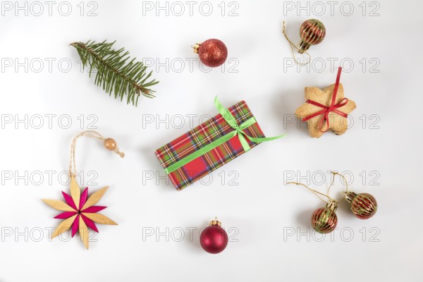 Christmas and New Year composition. Christmas gift, fir tree branches, cookies with festive decoration, wooden star. Flat lay on white background, top view
