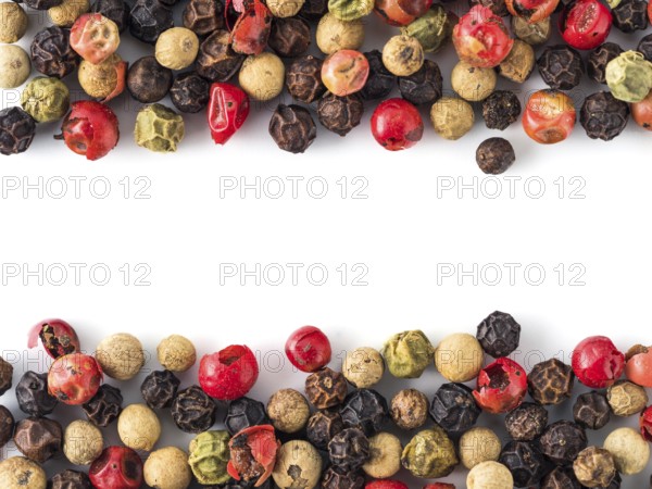 Mixed peppercorns background with white copy space in center. Food background with peppercorns. Different colored peppercorns pattern on white background, top view or flat lay
