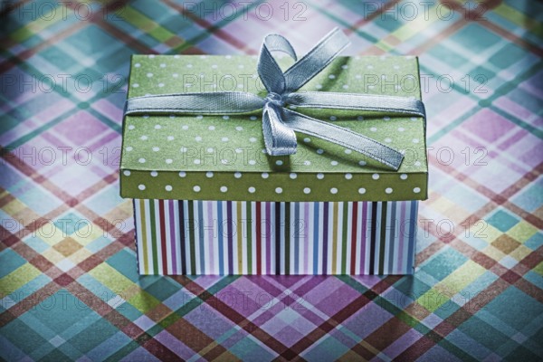 Present in cardboard box on checked fabric holidays concept