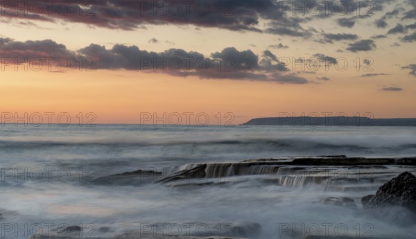 Dramatic beautiful sunset on a rocky coast at Akrotiri area in Limassol, Cyprus. Long exposure photography
