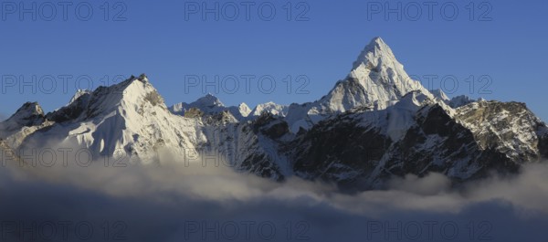 Mount Ama Dablam and other snow covered mountains reaching out of a sea of fog, Nepal, Asia