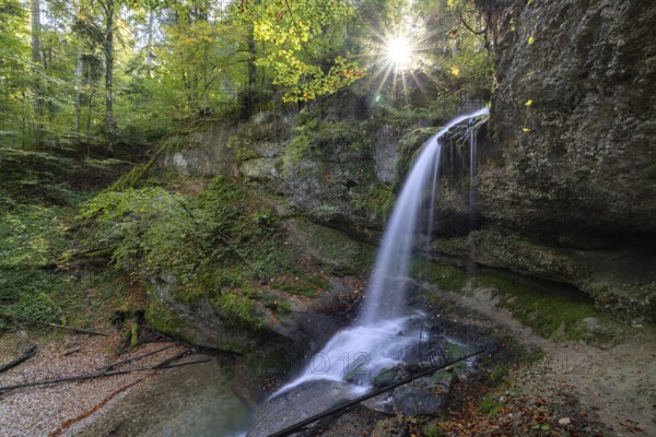 A waterfall in the forest with sunbeams through the trees, peaceful and natural, Hasenreuter Wasserfall, Scheidegg, Bavaria, Germany, Europe
