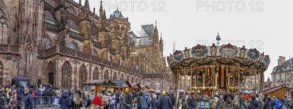 Panoramic photo of the carousel at the Christmas market at the High Gothic Strasbourg Cathedral, Strasbourg, Alsace, France, Europe