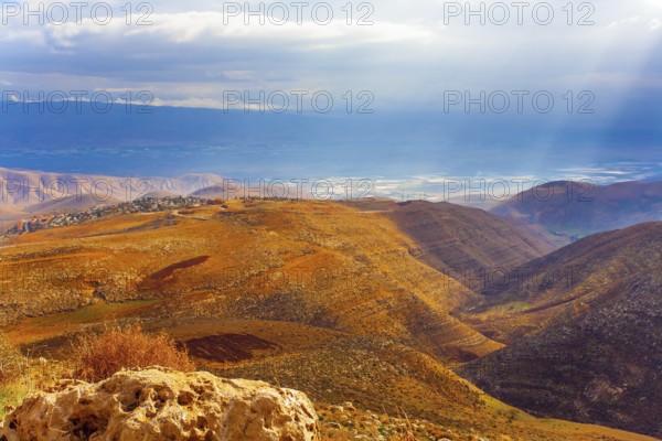 Legendary Dead Sea. Ancient terracotta-colored mountains surround the healing waters of the Dead Sea. The sun's rays illuminate the picturesque hills. Israel