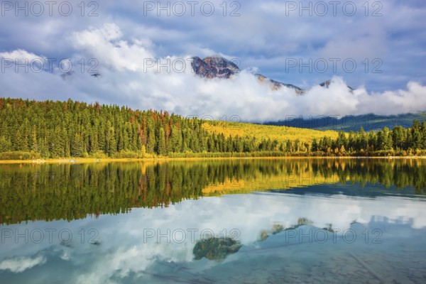 Charming Patricia Lake amongst the evergreen forests, yellow bushes and mountains. Autumn in Jasper Park, Canadian Rockies