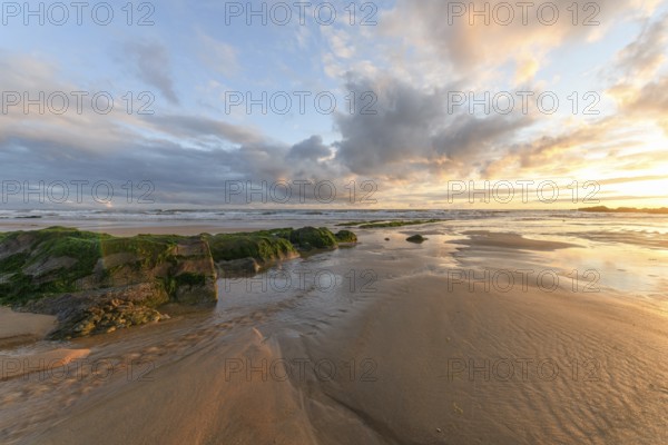 Sunset at the atlantic Ocean with orange beach and sky in France