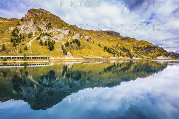 Mountain Lake Lago di Fedaia. The magic and harmony of the Dolomites. Glacial lake with cold water. The concept of ecological and extreme tourism