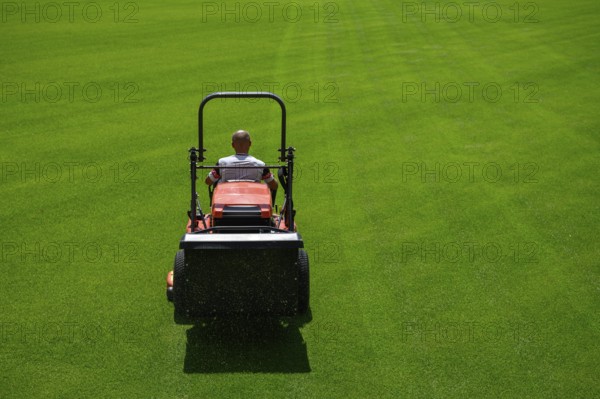 Mowing grass at the football stadium in Lubin, Poland, Europe