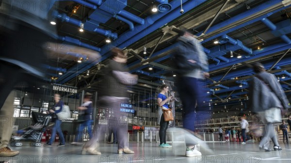 Low angle view of visitors walking through the large hall of the Georges Pompidou Centre in France