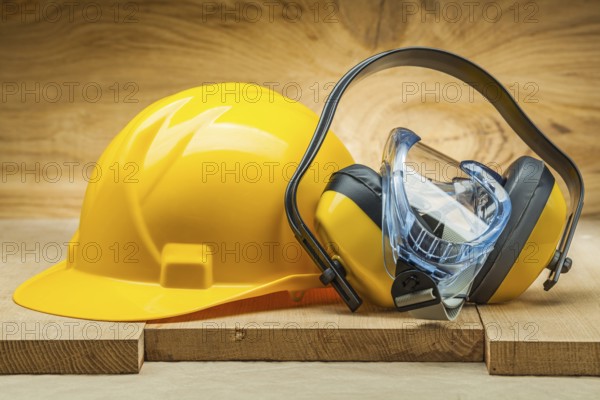 Earphones with blue goggles and yellow helmet. safety tools
