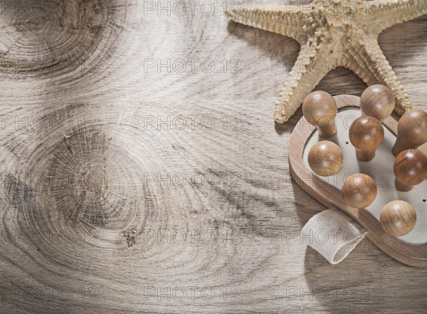 Starfish massager on wooden board copy space spa concept