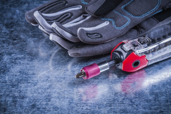 Threaded muunction screwdriver fabric protective gloves on metallic background