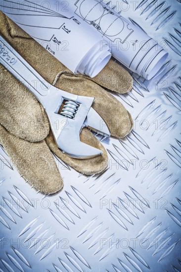 Safety gloves engineering drawings monkey wrench on grooved metal sheet construction concept