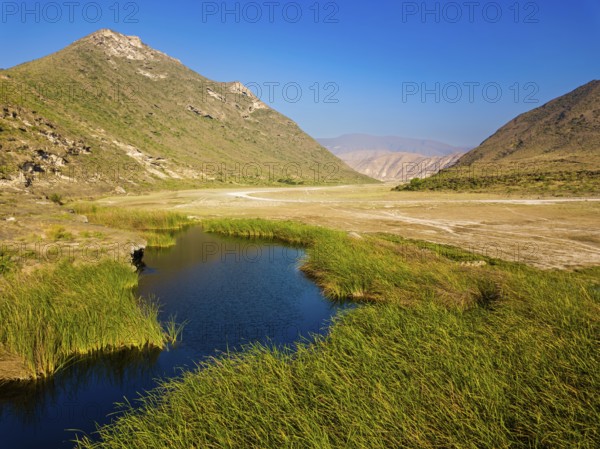 Landscape in Oman, mountains, Wadi Ashawq, road, reeds, waters Salalah, Al Mughsyal / Wadi Ashawq, Dhofar, Oman, Asia