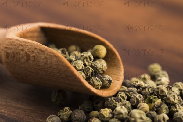 Green peppercorns on a wooden background