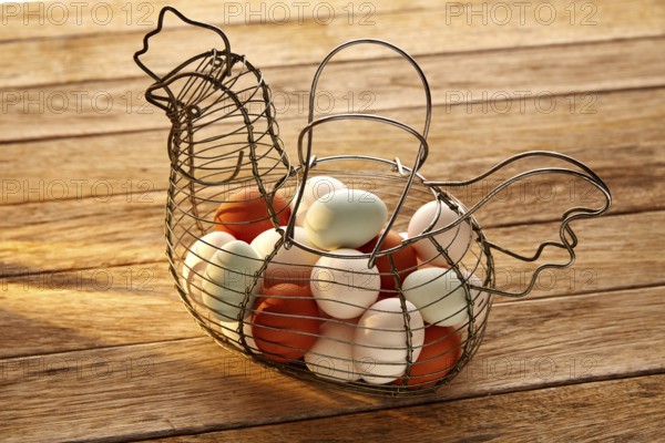 Eggs in a vintage hen shape basket on wood with blue easter white and brown colors