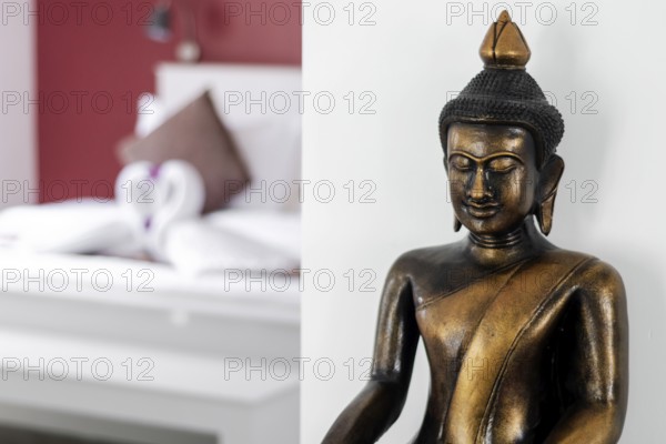 Bronze buddha statue interior design detail in modern asian home living room
