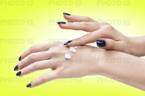 Beautiful female hands with cream on the green background