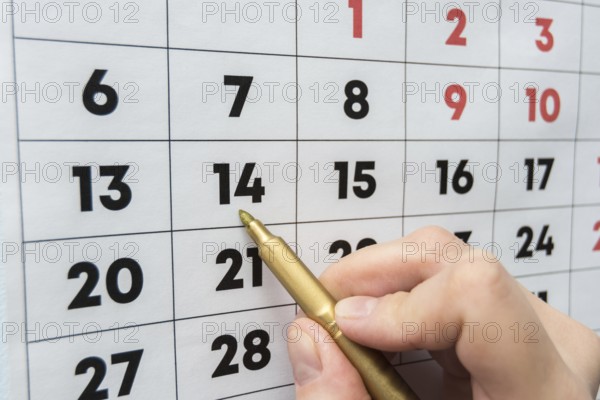 Hand marker indicates the date on the wall calendar