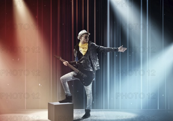 Young man rock musician in lights of stage