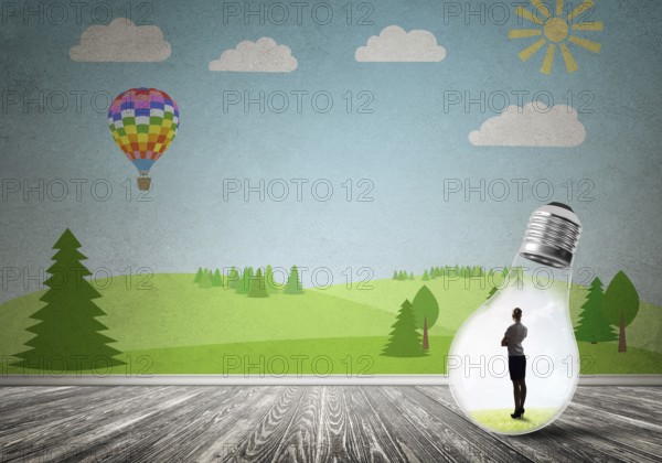 Businesswoman inside light bulb in room against nature drawn concept
