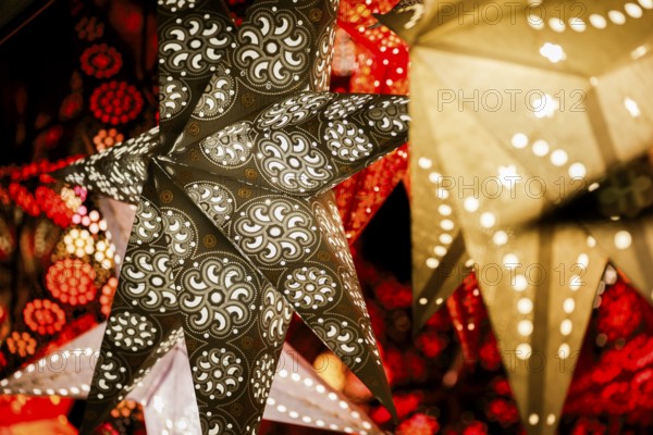 Decorative, illuminated stars with an artistic pattern create a warm, Christmassy atmosphere at a Christmas market, Cologne, North Rhine-Westphalia, Germany, Europe