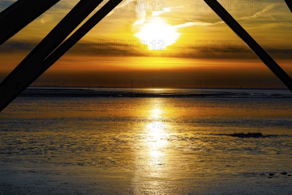 Sunset over the mudflats with dramatic colours and silhouettes in the foreground, Dorum-Neufeld harbour 27639 Wurster North Sea coast, Germany, Europe
