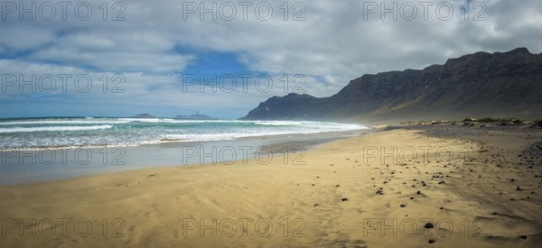 Panorama view on Famara beach on the Canary Island of Lanzarote, with some windsurfing in the far distance