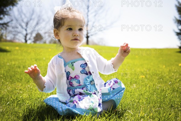 Pretty little girl playing in the grass during summer, Toronto, Canada, North America