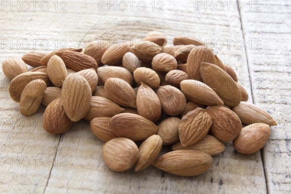 Close-up of almonds, piled up on wooden table