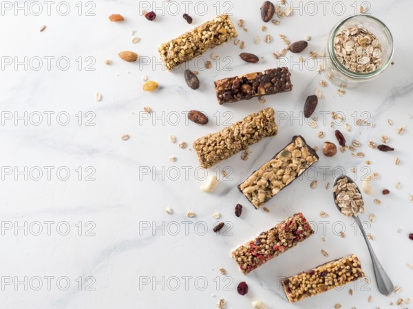 Granola bar with copy space. Set of different granola bars on white marble table. Shallow DOF. Top view or flat lay
