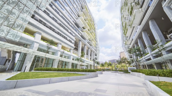 Niedriger Blick auf die Perspektive des leeren Pflasters und des modernen Bürogebäudes mit grünem Öko-Konzeptbalkon