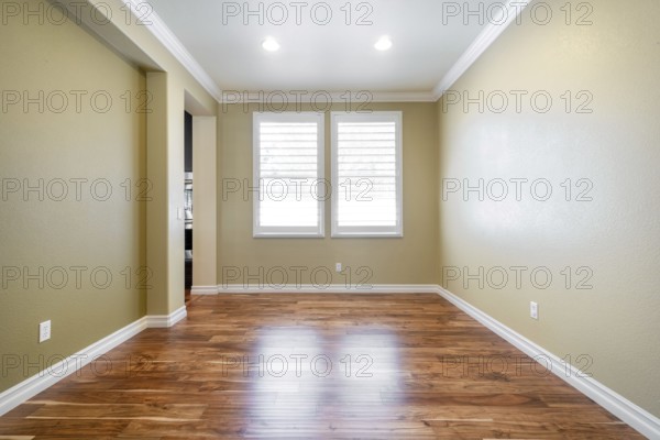 Bright beige large empty room with wood floor, molding and windows. Modern bright room, interiors