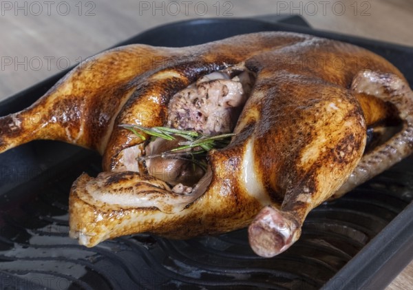 Close-up of a whole roasted or slow-baked duck in a frying pan