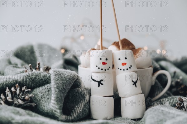 Two happy funny marshmallow snowmen. Marshmallow friends. Diy. Sweet treat for kids funny marshmallow snowman. Christmas winter holiday decoration. New year greeting card. Christmas lights. Cup of cacao
