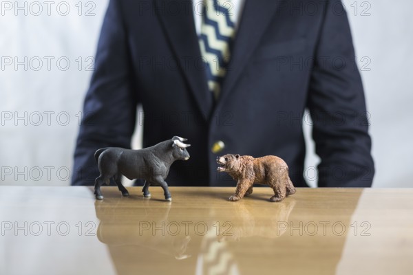 Stock market, securities trading and capitalism concept with a bull and bear concepts. Business trader man in suit in background