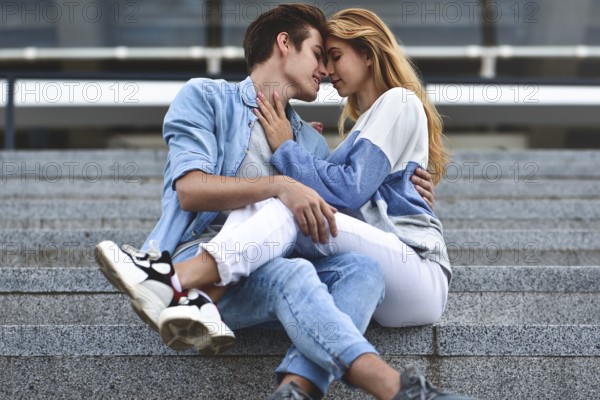 Happy to spending time together. Young beautiful couple outdoor fashion portrait. Attractive boy and girl hugging and kissing