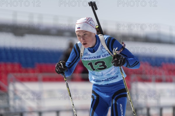 Sportsman biathlete Protasov Dmitry skiing on ski track distance biathlon stadium during Junior biathlon competitions East Cup. Petropavlovsk City, Kamchatka Peninsula, Russian Far East, Apr 14, 2019