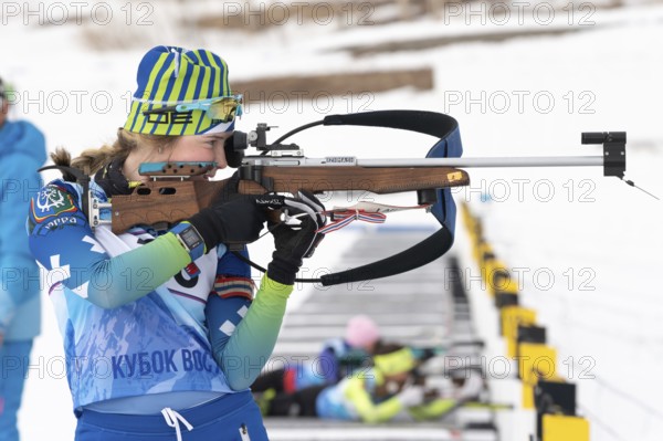 Sportswoman biathlete Legostaeva Anastasia rifle shooting in standing position. Biathlete in shooting range. Open regional youth biathlon competitions East Cup. Kamchatka, Russia, April 12, 2019, Europe